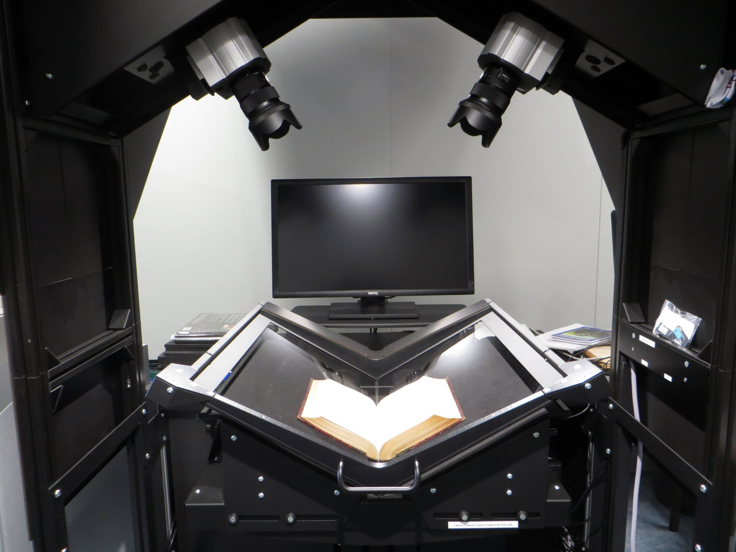 Dispositif de numérisation avec un livre ancien ouvert sur support en V.
