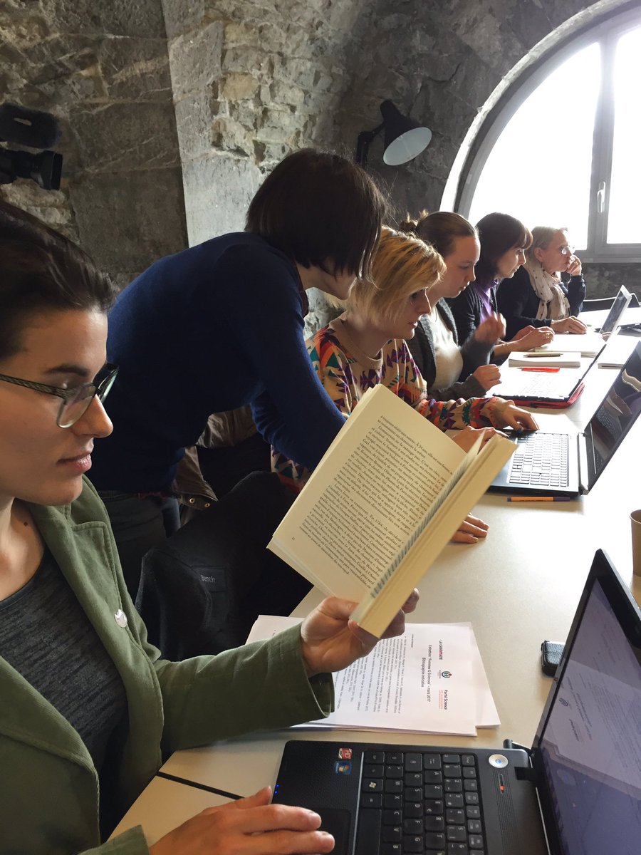 Six personnes contribuent, alignées, à Wikipédia. Au premier plan, l'une d'elles tient un livre dans une main.